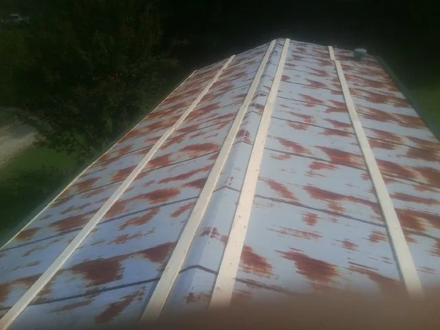 Rusted metal roof panels with new wood purlins before replacement — Storm Damage Roof Repair in Flomaton by Roofing Brothers