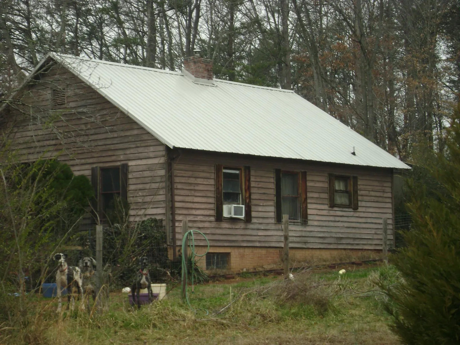 White metal roof on an old wood sided farmhouse, from a Asphalt Shingle Roof Repair job in Flomaton
